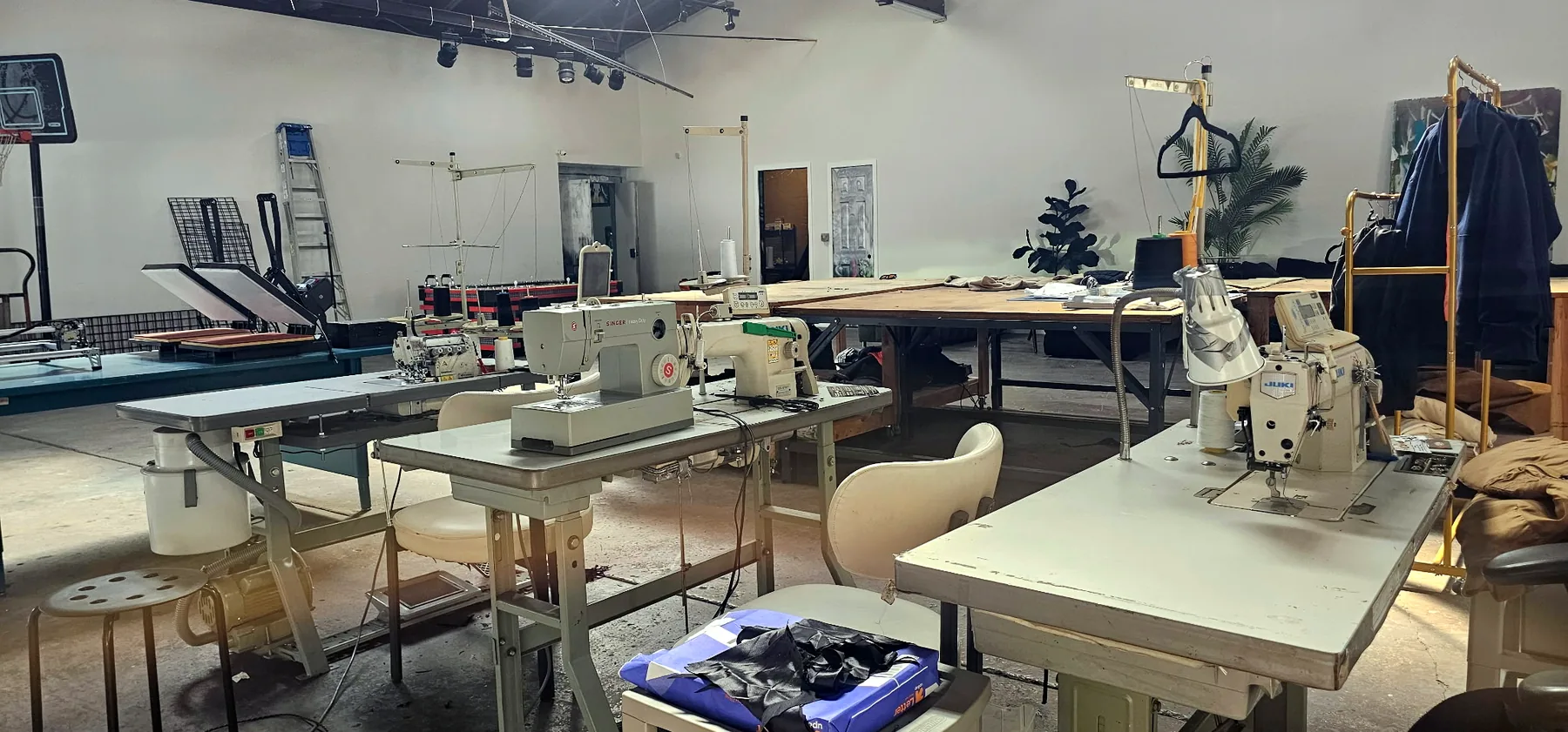 Industrial sewing machines and heat presses on the studio floor